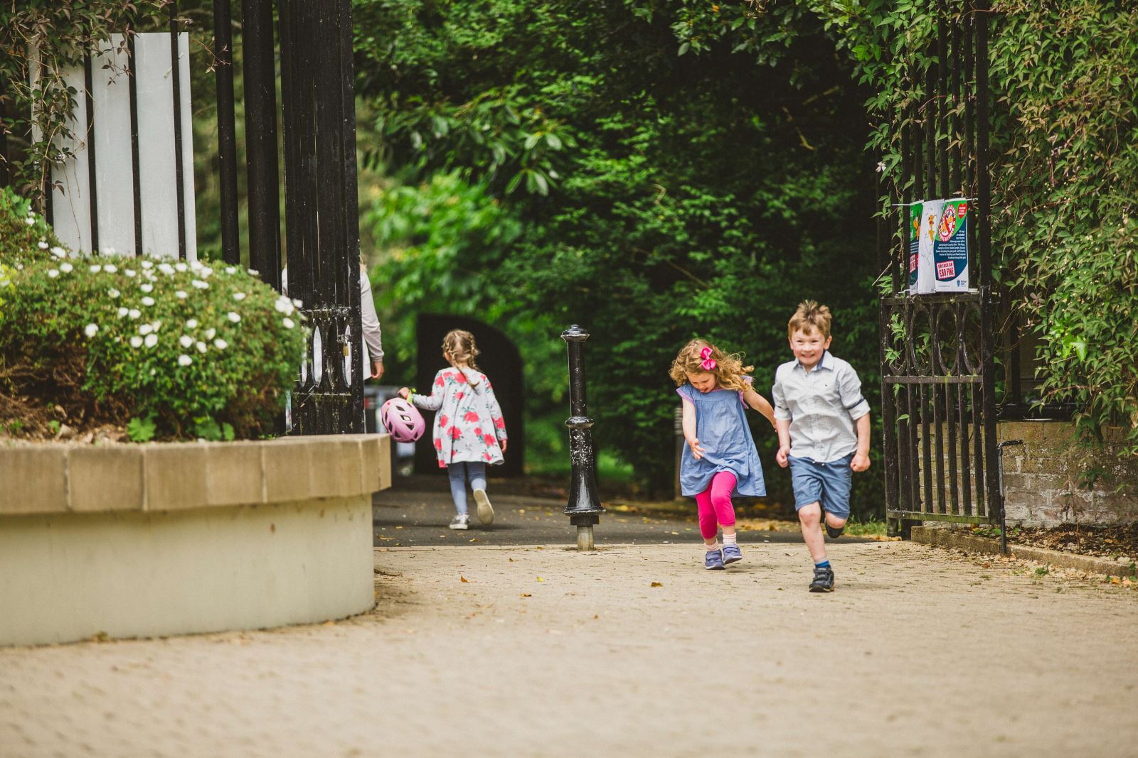 Two children (boy & girl) running through Carnfunnock Country Park looking excited